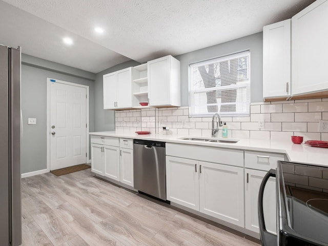 kitchen with open shelves, appliances with stainless steel finishes, a sink, and light countertops