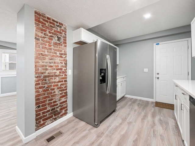 kitchen with light countertops, appliances with stainless steel finishes, light wood-style flooring, and visible vents