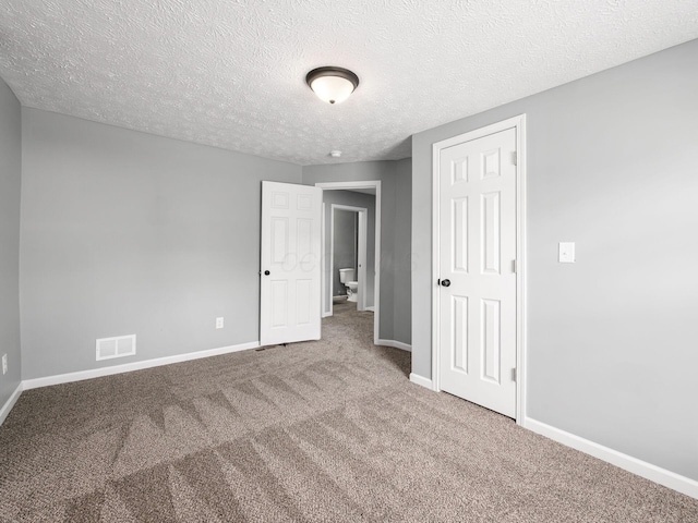 unfurnished bedroom with carpet, visible vents, and baseboards