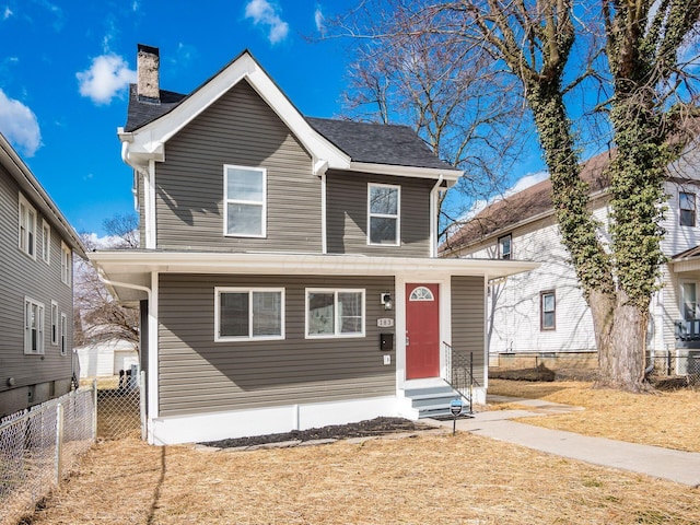 view of front of house featuring entry steps, fence, a chimney, and a front lawn