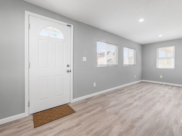 entryway featuring light wood finished floors, baseboards, and recessed lighting