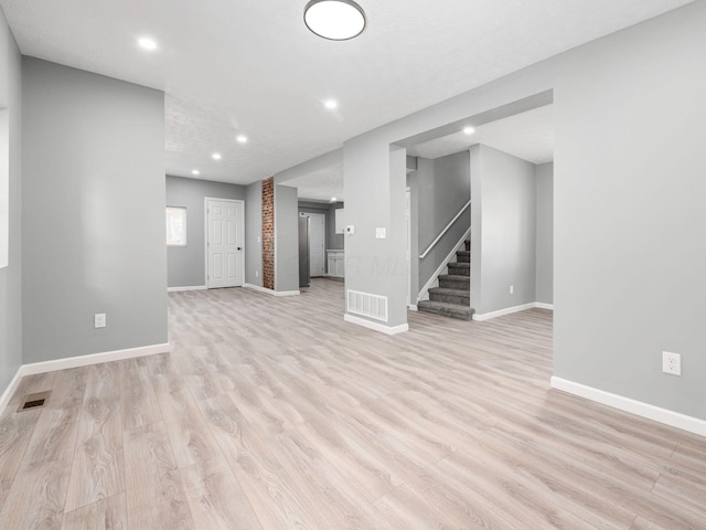 interior space with light wood-style floors, stairs, and visible vents