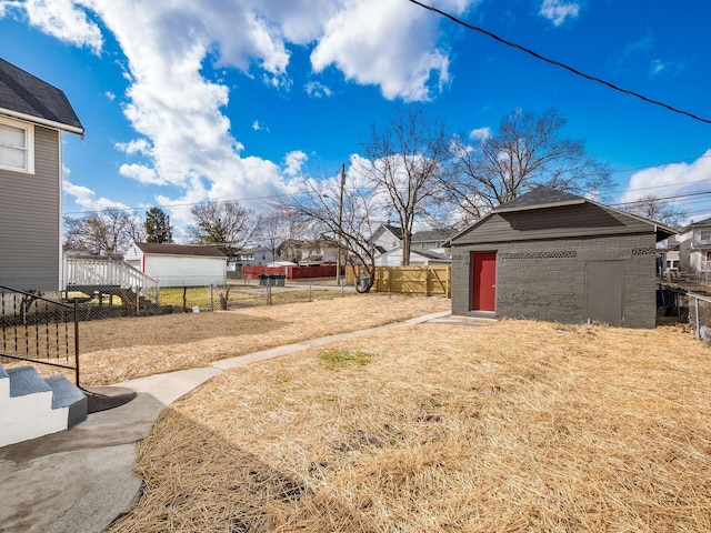 view of yard with fence and an outbuilding