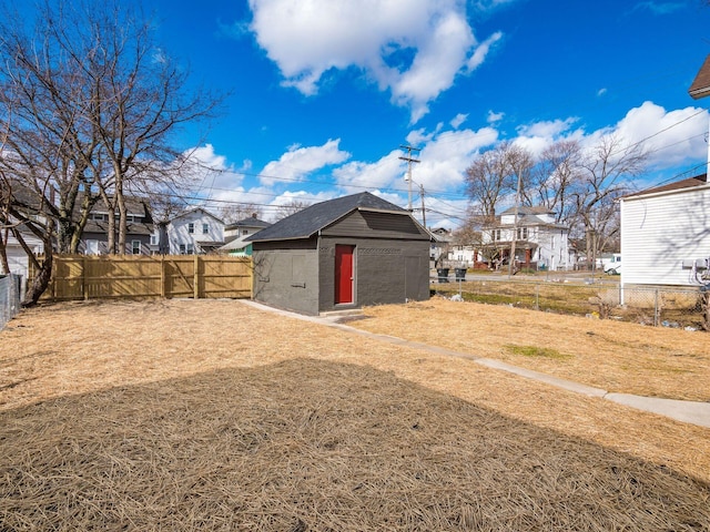 view of yard with an outbuilding, a fenced backyard, and a residential view