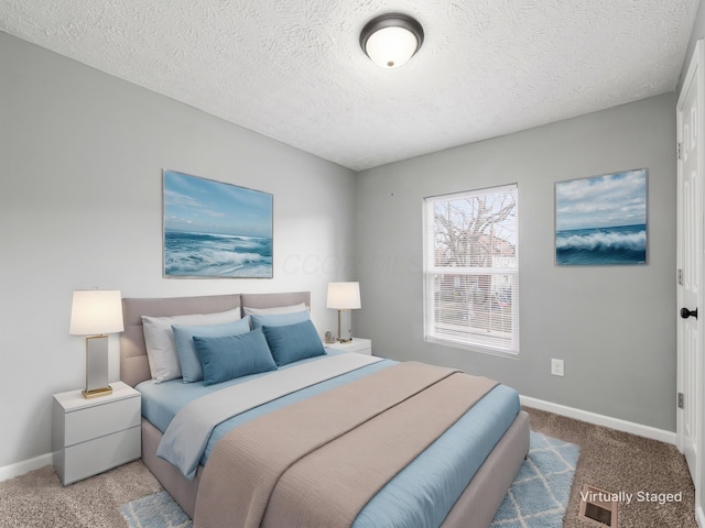 carpeted bedroom featuring baseboards and a textured ceiling