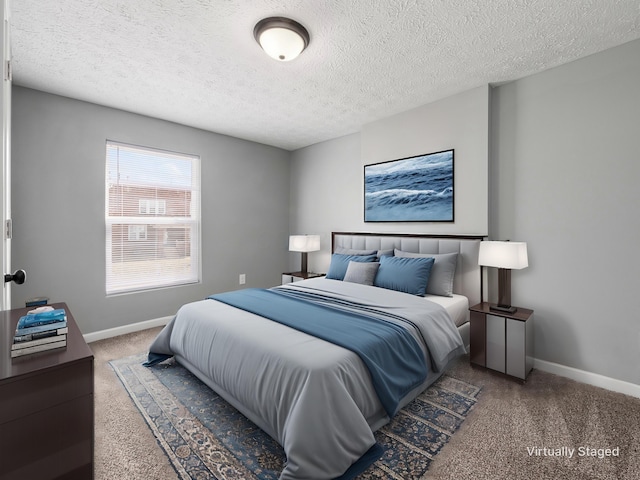 bedroom featuring a textured ceiling, carpet floors, and baseboards