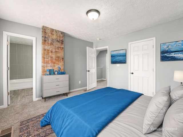 carpeted bedroom with a textured ceiling, baseboards, visible vents, and ensuite bathroom