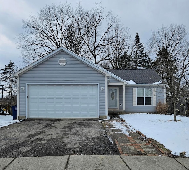 single story home with aphalt driveway and an attached garage