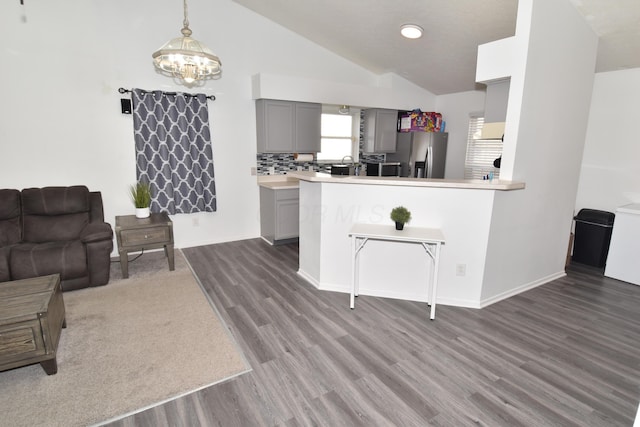 kitchen with pendant lighting, gray cabinets, light countertops, open floor plan, and stainless steel fridge with ice dispenser