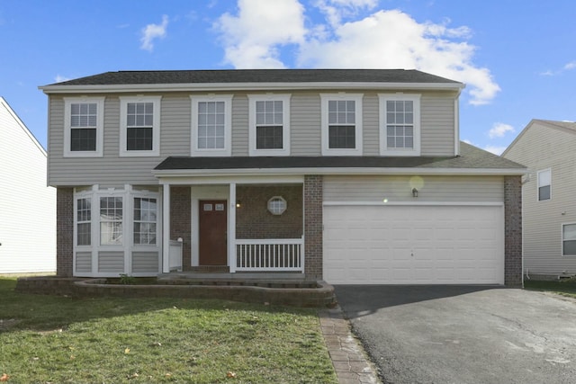 view of front facade with driveway, covered porch, a front yard, and brick siding