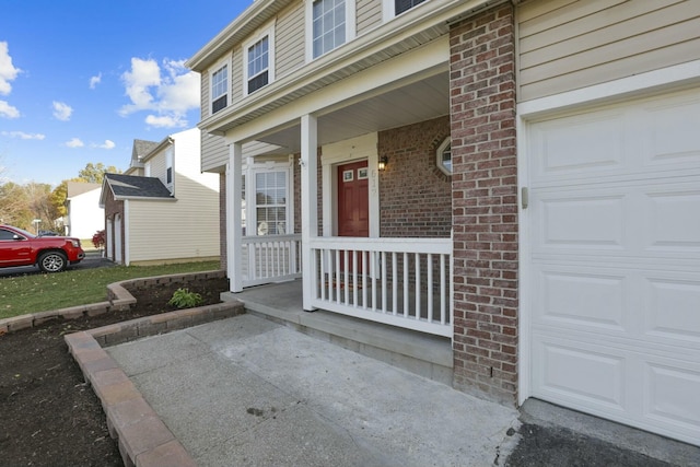 entrance to property with covered porch and brick siding