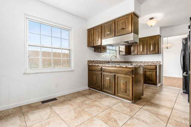 2715 Kenview Rd S, Columbus, OH 43209 - kitchen with under cabinet range hood, light countertops, baseboards, and visible vents