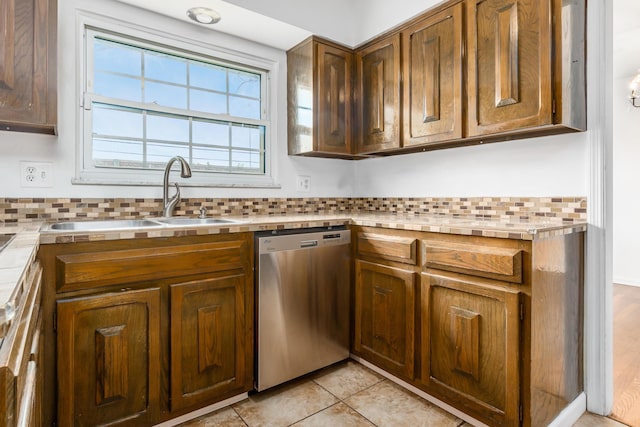 2715 Kenview Rd S, Columbus, OH 43209 - kitchen with light tile patterned floors, a sink, brown cabinetry, stainless steel dishwasher, and tasteful backsplash