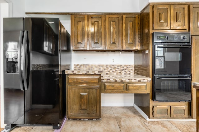 2715 Kenview Rd S, Columbus, OH 43209 - kitchen featuring brown cabinetry, light tile patterned flooring, decorative backsplash, black appliances, and light countertops