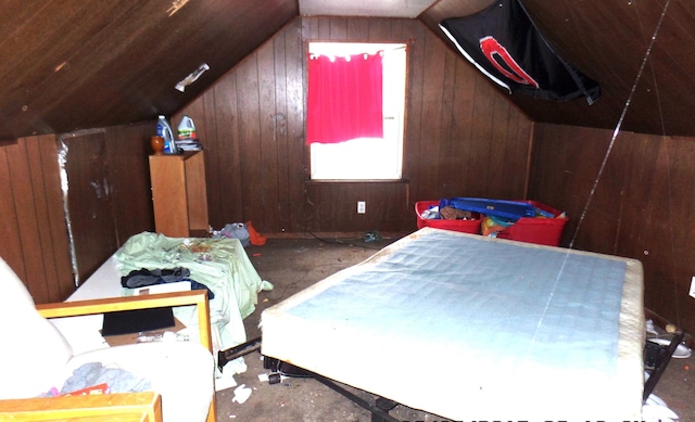 interior space featuring lofted ceiling and wooden walls