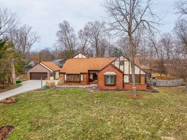 view of front of home featuring a front yard, a garage, brick siding, and driveway