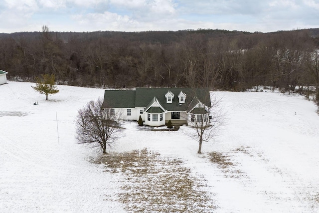 snowy aerial view featuring a forest view