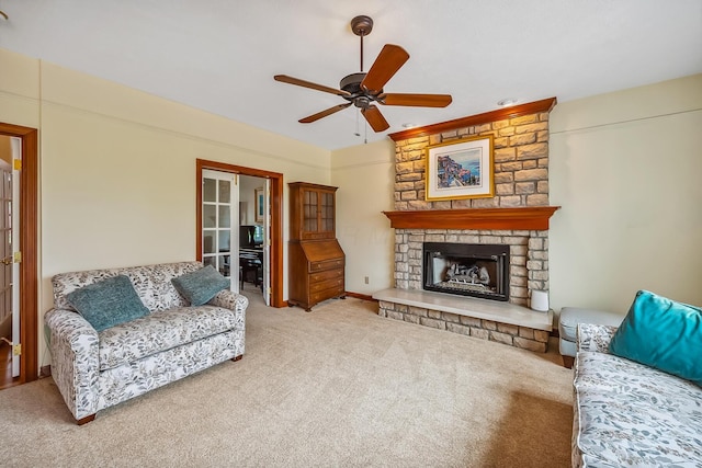 living area featuring a ceiling fan, french doors, carpet, and a fireplace