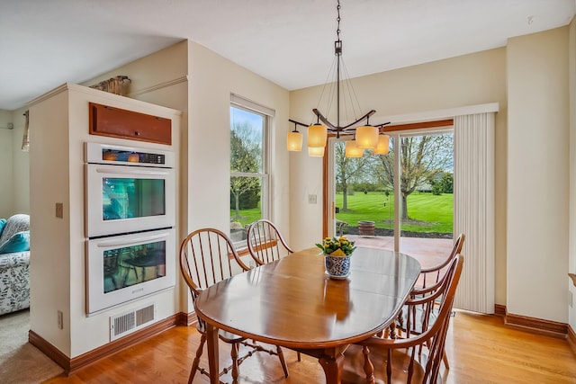 dining room with a wealth of natural light, a notable chandelier, visible vents, and baseboards