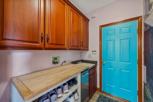 washroom with wet bar, a sink, cabinet space, and hookup for a washing machine