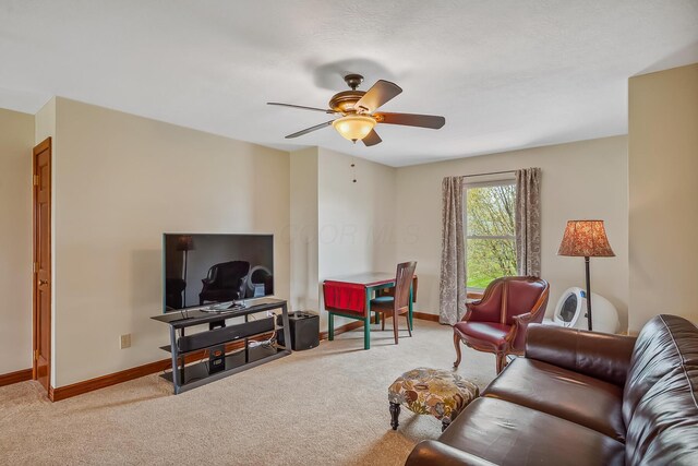 living room with a ceiling fan, baseboards, and carpet floors