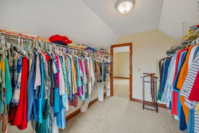 spacious closet with vaulted ceiling and carpet flooring
