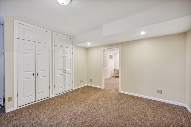 unfurnished bedroom featuring recessed lighting, carpet floors, multiple closets, and baseboards