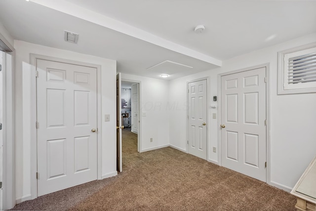 interior space featuring baseboards, visible vents, and carpet