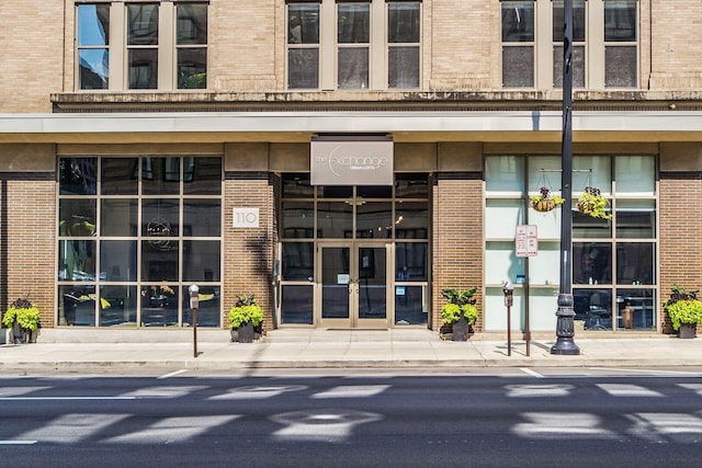 view of exterior entry featuring brick siding