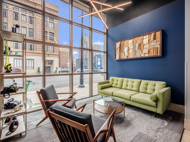 living room with a wall of windows, a view of city, and a high ceiling