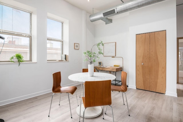 dining room with baseboards, visible vents, and light wood finished floors