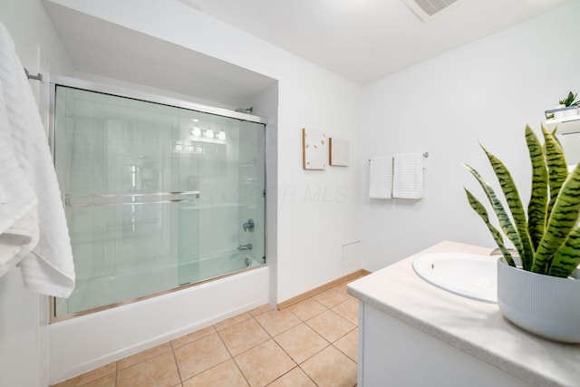 bathroom with visible vents, bath / shower combo with glass door, baseboards, tile patterned flooring, and vanity