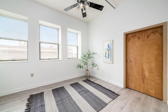 interior space featuring ceiling fan, light wood-style flooring, and baseboards