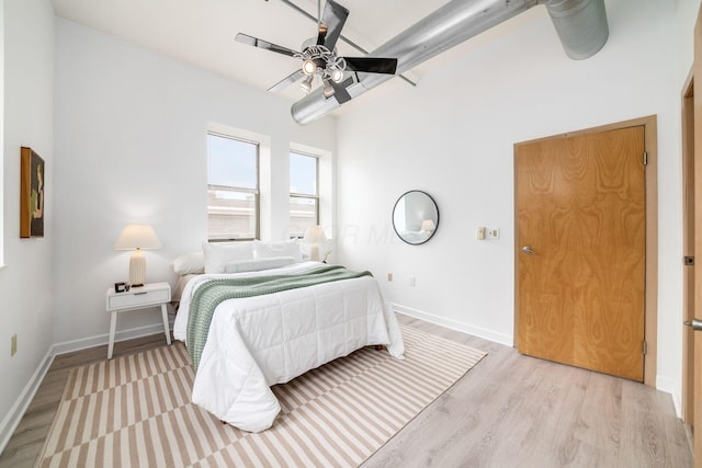 bedroom featuring ceiling fan, light wood finished floors, and baseboards