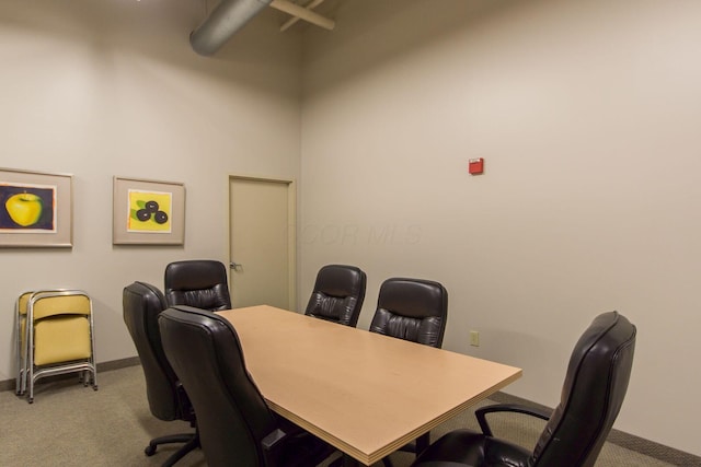 office area featuring baseboards and light colored carpet