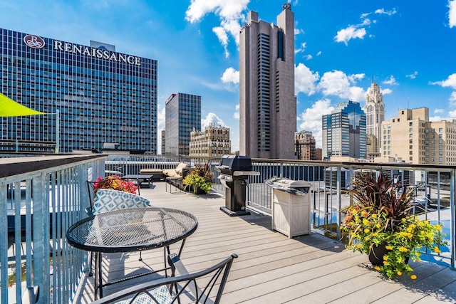 wooden terrace featuring grilling area and a city view