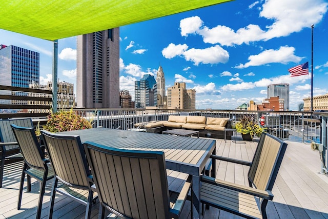 wooden deck with a view of city and an outdoor hangout area