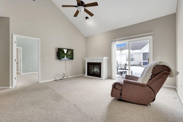 living room with baseboards, a ceiling fan, a glass covered fireplace, carpet, and high vaulted ceiling