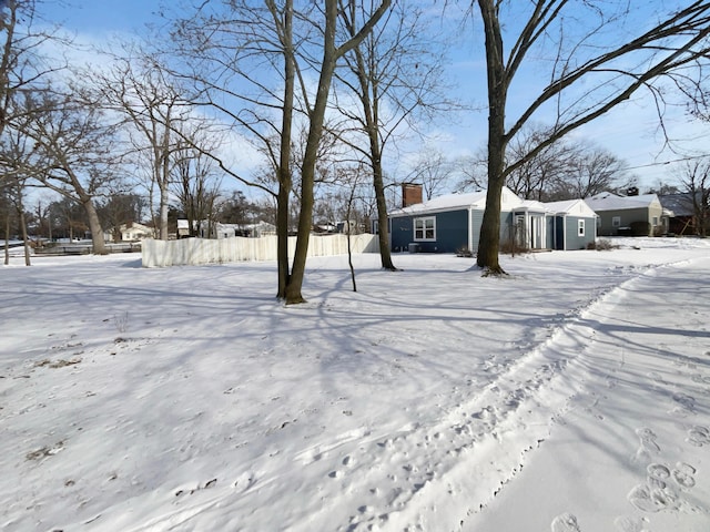 yard layered in snow featuring fence