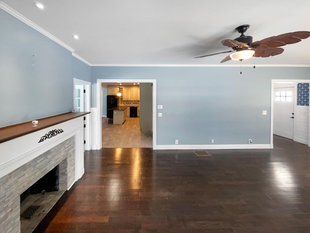 unfurnished living room with ornamental molding, a fireplace, dark wood finished floors, and baseboards