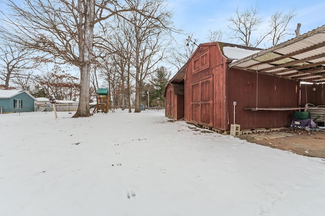 yard layered in snow with a barn and an outdoor structure