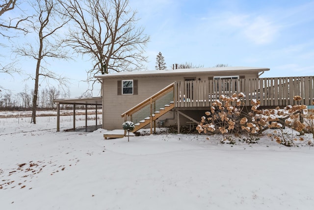 snow covered back of property with fence and a deck