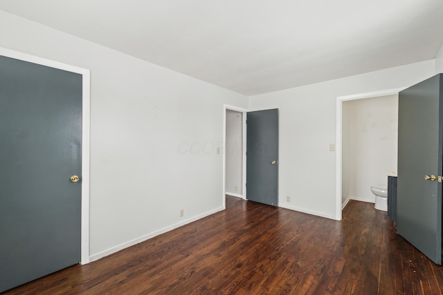 unfurnished bedroom featuring baseboards and dark wood finished floors