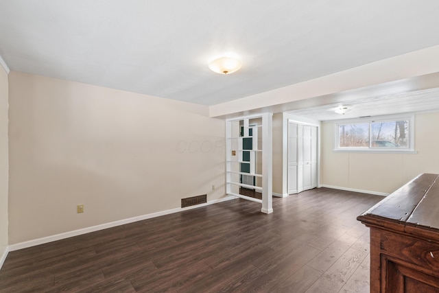 interior space with dark wood-style floors, baseboards, and visible vents