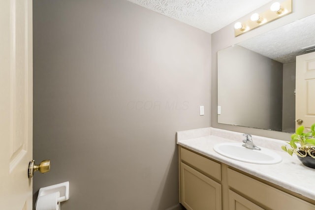 bathroom featuring a textured ceiling, visible vents, and vanity