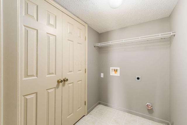 clothes washing area featuring a textured ceiling, hookup for a washing machine, laundry area, baseboards, and electric dryer hookup