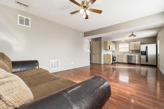 living room with dark wood-style floors and visible vents