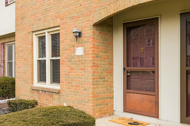 doorway to property with brick siding