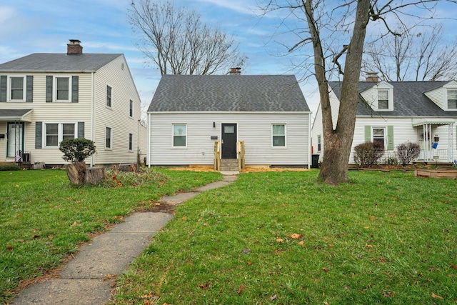 view of front facade with crawl space, roof with shingles, and a front yard