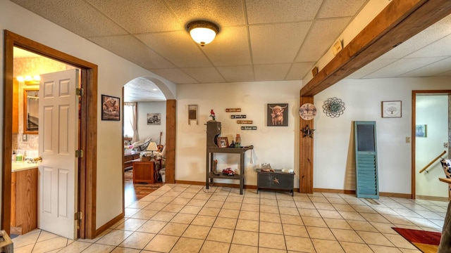 1295 Maple Brook Rd, New Concord, OH 43762 - corridor featuring light tile patterned floors, a paneled ceiling, arched walkways, and baseboards